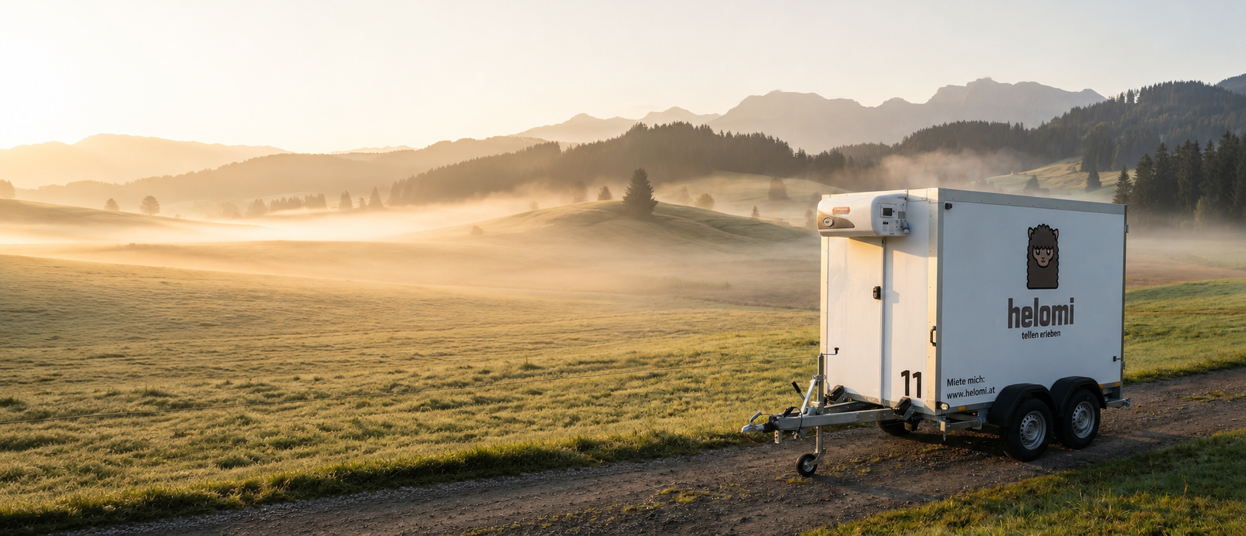 helomi Kühlanhänger Nr. 11 auf einer nebligen Bergwiese bei Sonnenaufgang